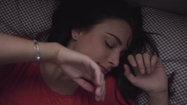 Lassított felvétel, egy fiatal kaukázusi lány felébred az ágy. - Felvétel, videó