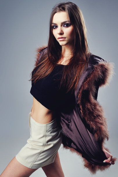 Portrait of attractive stylish woman in fur against grey background. - Foto, imagen
