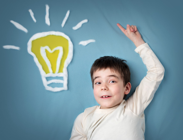 seven years old boy and a bulb near. Child with an idea - Foto, Imagem