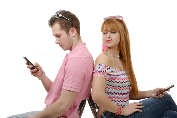 Young couple talking on mobile phones sitting back to back. - Фото, изображение