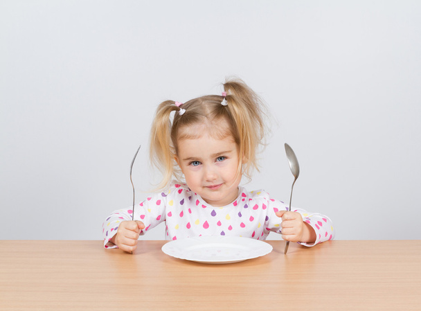 Little girl holding fork and spoon with  - Foto, immagini