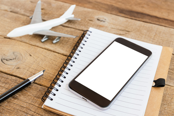 telefon boş ekran ve uçak model ahşap masa üzerinde - Fotoğraf, Görsel