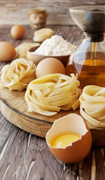 Uncooked pasta with flour on the table, selective focus - Valokuva, kuva