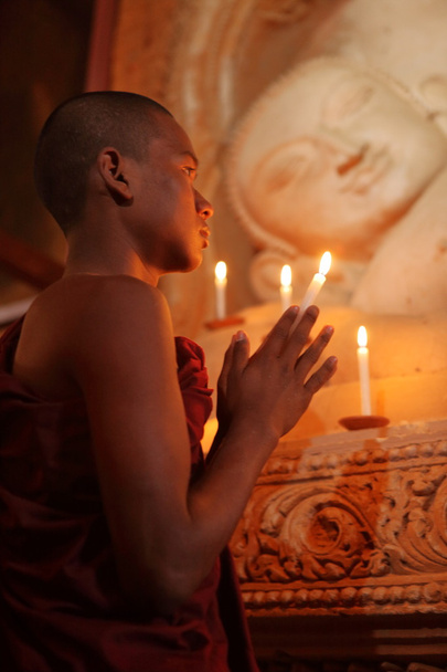 Buddhistischer Mönch beim Gebet bei Kerzenschein - Foto, Bild