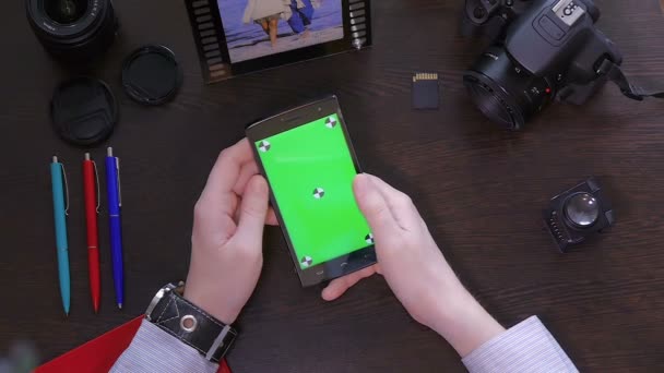 Hombre utiliza teléfono móvil con pantalla verde vista superior
 - Metraje, vídeo