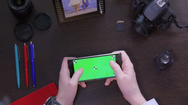 Mężczyzna używany telefon komórkowy z zielonego ekranu widok z góry - Materiał filmowy, wideo