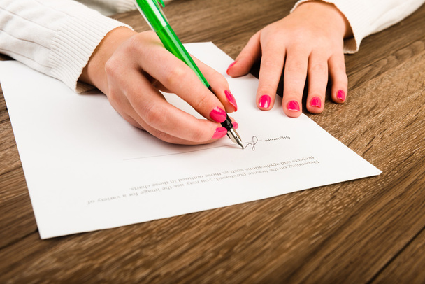 Geschäftsfrau mit Kugelschreiber unterschreibt Vertrag - Foto, Bild