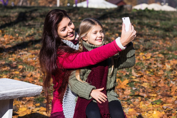 Mother and daughter are doing selfie in the park.Mom and daughter in the park - Foto, Bild