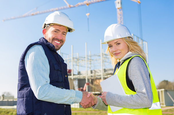 architect and worker handshaking on construction site  - Zdjęcie, obraz