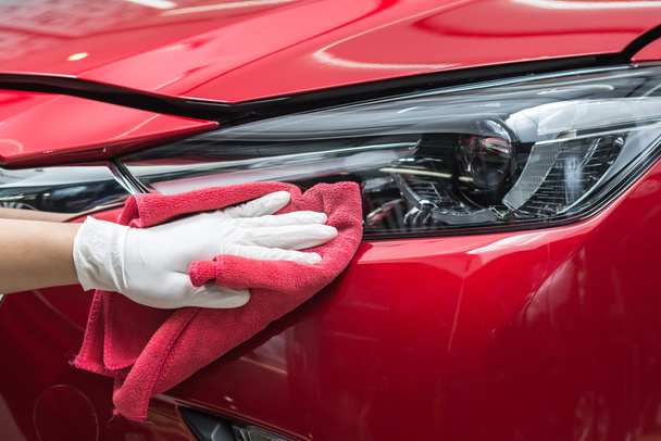 Auto detaillering serie: werknemer rode auto schoonmaken - Foto, afbeelding
