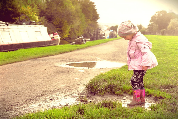 Nuori tyttö leikkii mutainen lätäkkö kanavalla polku
 - Valokuva, kuva