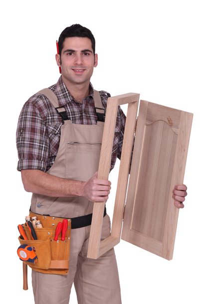 Carpenter with a cupboard door - Фото, зображення