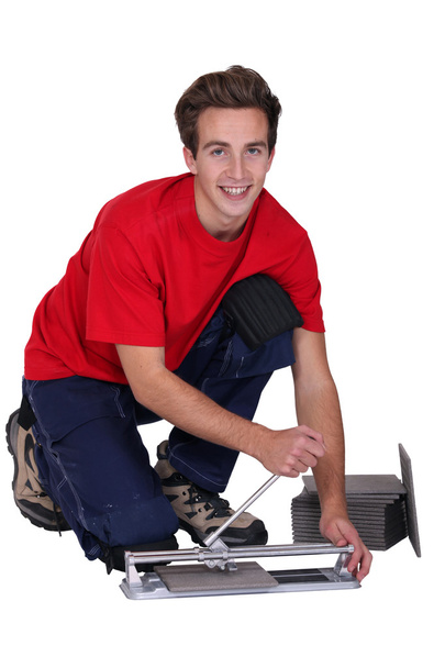 Молодой человек использует резак для плитки
 - Фото, изображение