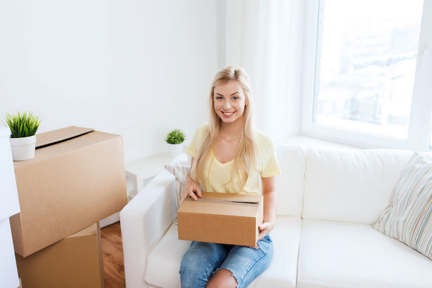 smiling young woman with cardboard box at home - Φωτογραφία, εικόνα