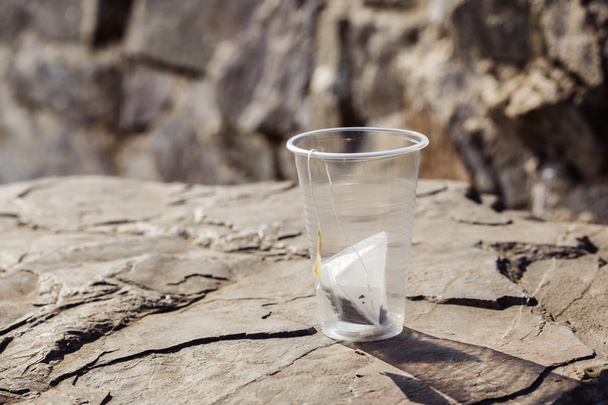 bolsa de té en una taza de plástico desechable en una roca en la naturaleza de nuevo
 - Foto, Imagen
