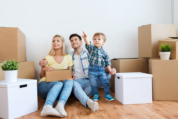 happy family with boxes moving to new home - Фото, изображение