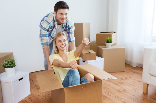 happy couple having fun with boxes at new home - Foto, Imagem