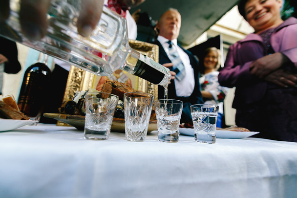 Guests pouring vodka at wedding - Foto, afbeelding