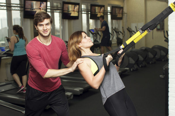 mooie sport fitness paar in de sportschool. Fitness-instructeurs met extra apparatuur - Foto, afbeelding