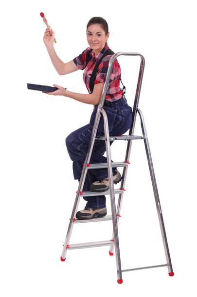 Female painter on ladder against white background - Foto, imagen