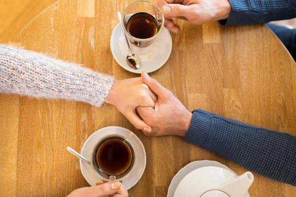 primer plano de pareja cogida de la mano en el restaurante - Foto, Imagen