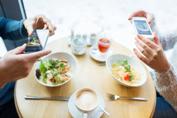 close up of couple picturing food by smartphone - Fotografie, Obrázek