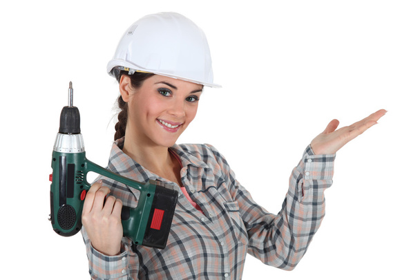 Craftswoman holding a drill - Foto, imagen