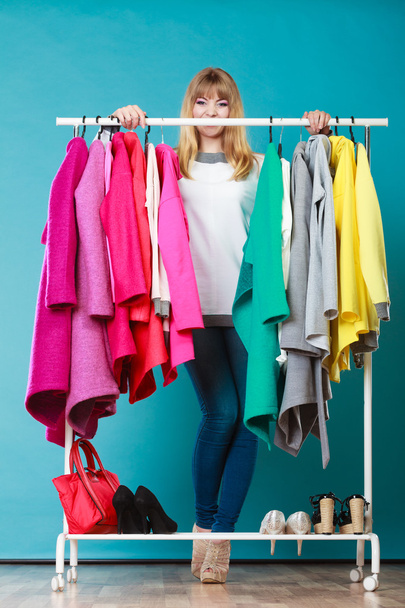 Woman choosing clothes to wear in mall or wardrobe - Valokuva, kuva