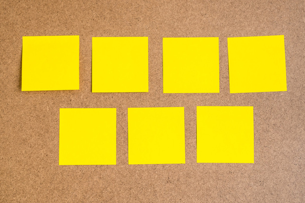Seven black yellow sticky notes on brown wood board - Photo, Image