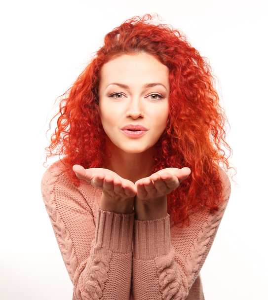 Red-haired young woman giving air kiss, isolated on white - Φωτογραφία, εικόνα