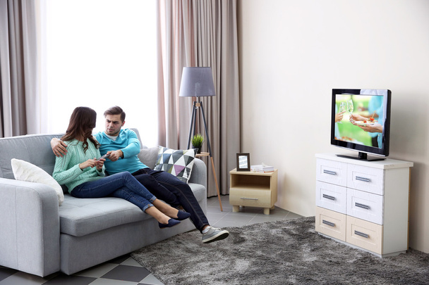 Young couple fighting for remote control  - Photo, Image