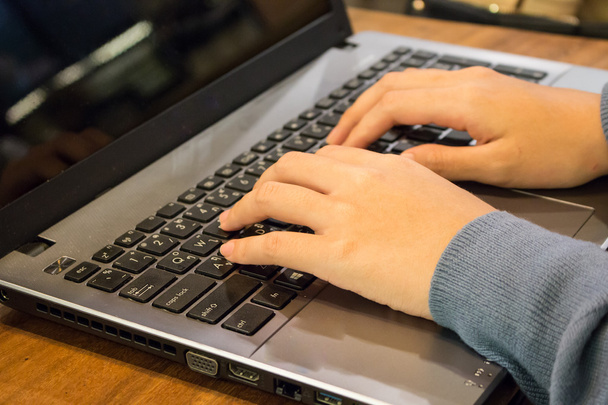 Рука азиатки-студентки, работающей на ноутбуке в кофейне
 - Фото, изображение