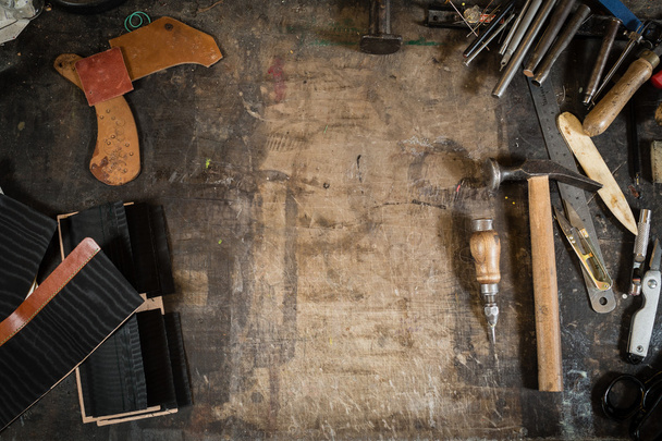 Herramientas de fabricación de cuero en el escritorio de trabajo con los arañazos
 - Foto, imagen