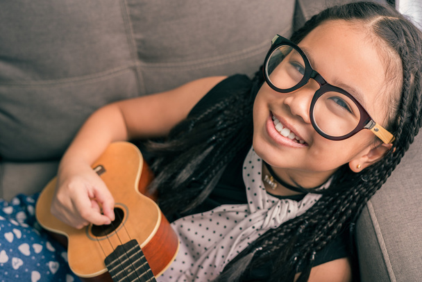 Onnellinen hymyilevä tyttö oppii soittamaan musiikkia
 - Valokuva, kuva