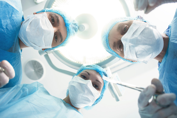 Skillful surgical team is performing an operation - Фото, зображення