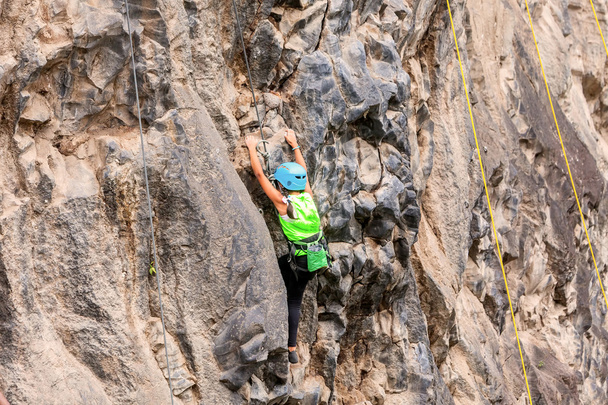 Chica valiente escalando una pared de roca
 - Foto, Imagen