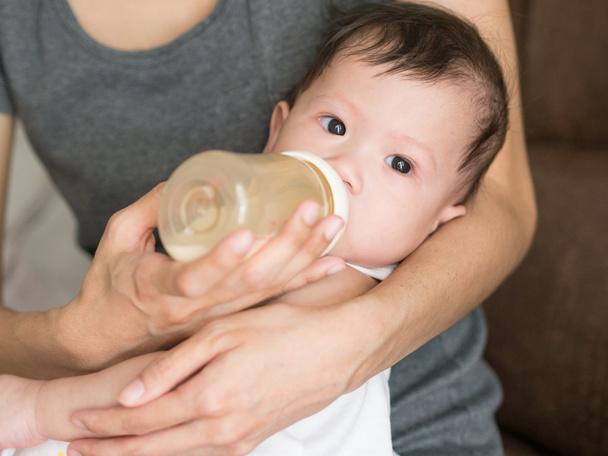 asiático madre alimentación leche su bebé en biberón
. - Foto, imagen
