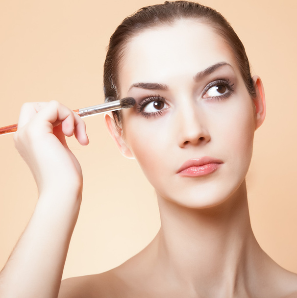 Close-up portrait of young beautiful woman with brush for make-u - Photo, Image