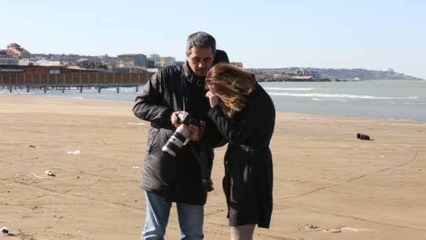 Mann fotografiert schöne Frau am Strand.  - Filmmaterial, Video