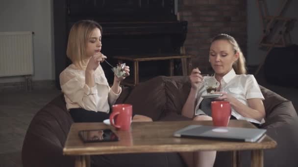 Dos mujeres de negocios comiendo postre y hablando
 - Imágenes, Vídeo