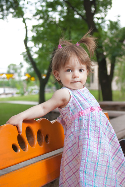 Девочка, стоящая на скамейке в парке
 - Фото, изображение
