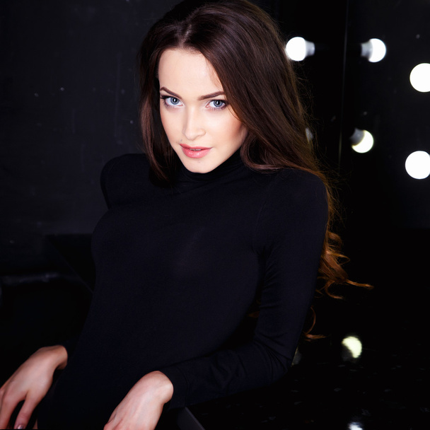 Beautiful young woman in black bodies over dark background in a dressing room. Beauty fashion portrait - Valokuva, kuva