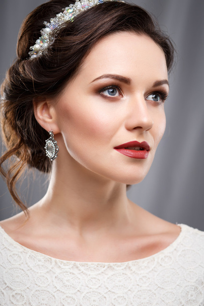 Elegant young woman with perfect makeup and hair style in a white dress. Beauty fashion portrait with accessories - Valokuva, kuva
