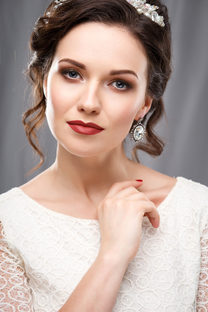 Elegant young woman with perfect makeup and hair style in a white dress. Beauty fashion portrait with accessories - Фото, зображення