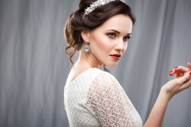 Elegant young woman with perfect makeup and hair style in a white dress. Beauty fashion portrait with accessories - Fotografie, Obrázek