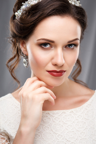 Elegant young woman with perfect makeup and hair style in a white dress. Beauty fashion portrait with accessories - Фото, изображение
