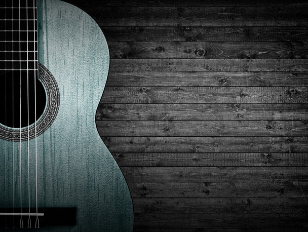 灰色の木製の背景に青いアコースティックギターの一部. - 写真・画像