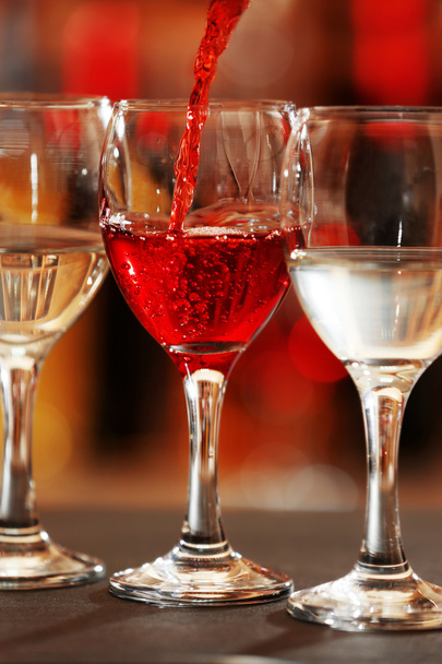 Red wine pouring into wine glass, closeup - Valokuva, kuva