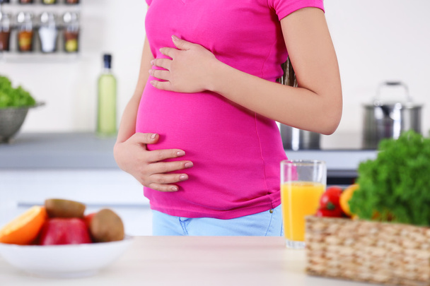 Pregnant woman in the kitchen - Valokuva, kuva