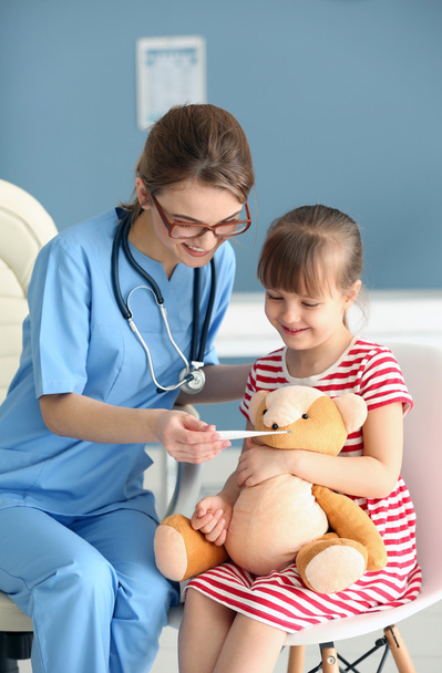 Doctor checking little girls temperature - Photo, Image
